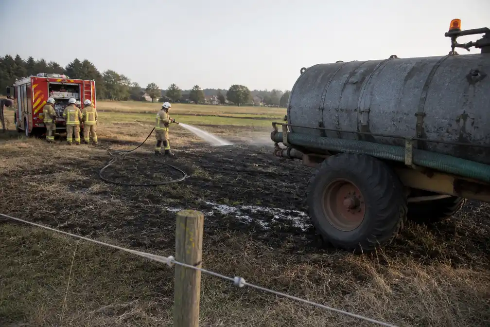 Brandweer bestrijdt weidebrand in Nieuwkerke, boer helpt met beerkar